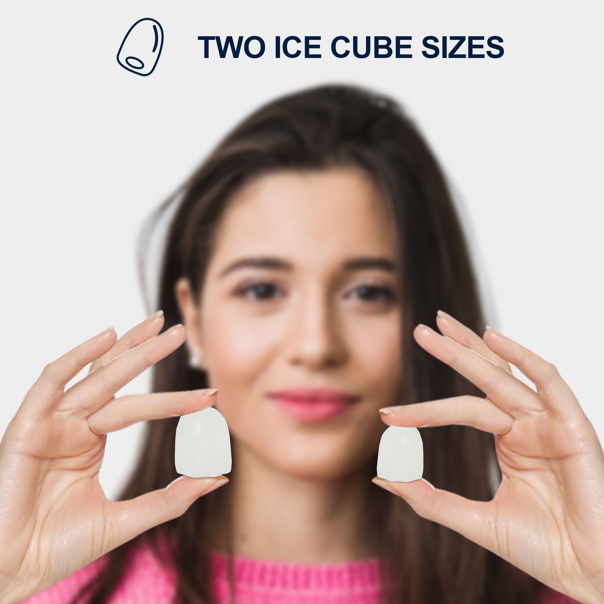 Head and shoulders of a person with light skin and long dark brown hair holding two bullet-shaped ice cubes, one large and one small, in front of her face. Text above reads, "Two ice cube sizes"