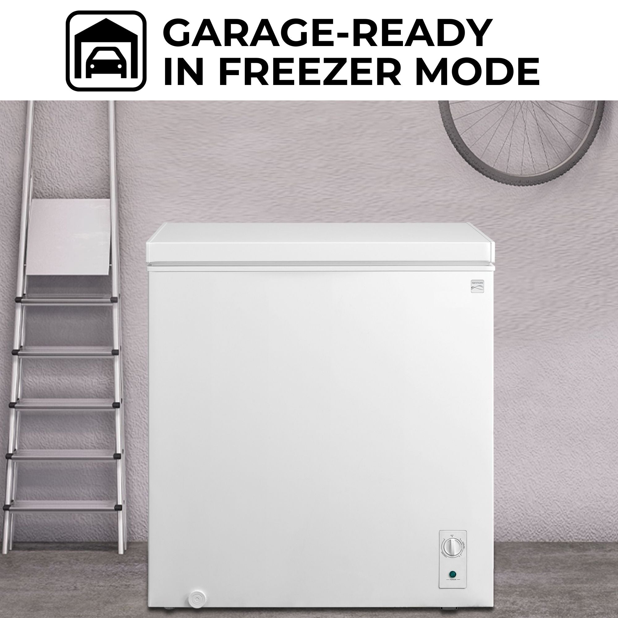 Kenmore convertible upright freezer/refrigerator, closed, in a garage with a light gray wall behind, metal ladder to the left and bike hanging above. Text above reads, "Garage-ready in freezer mode"